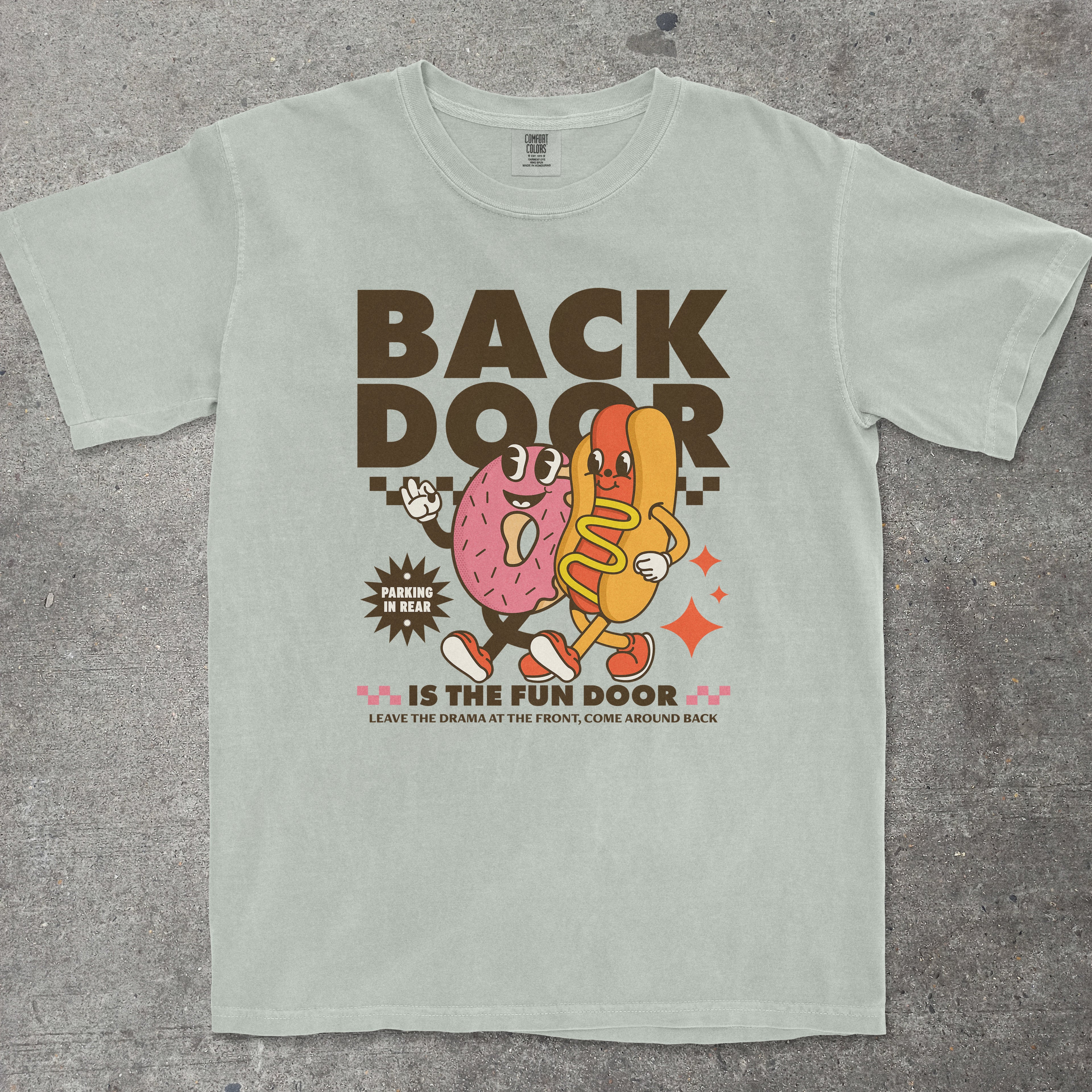 Light blue t-shirt with cartoon characters and text on a gray surface