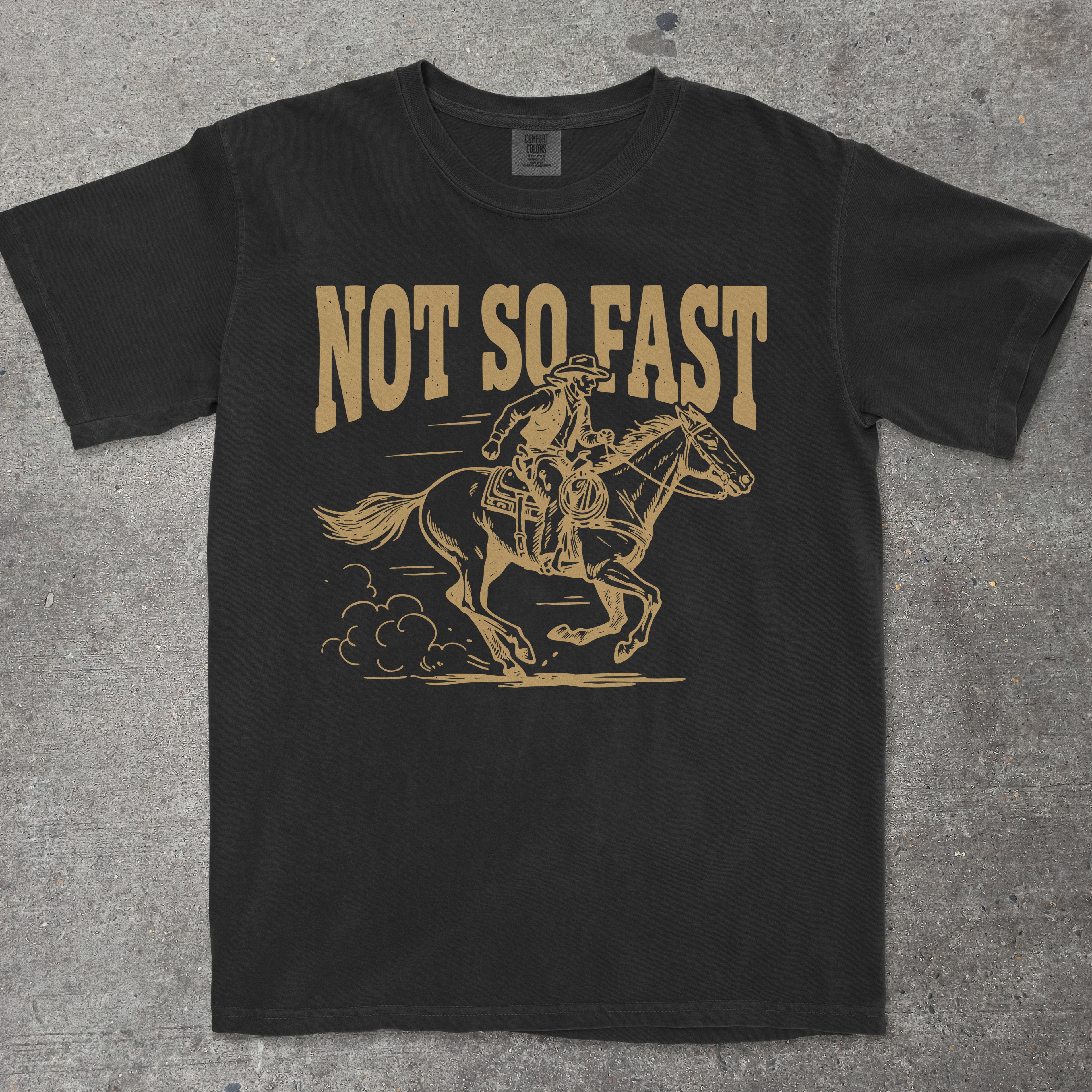 Black t-shirt with a graphic of a person on a horse and 'Not So Fast' text on a gray surface