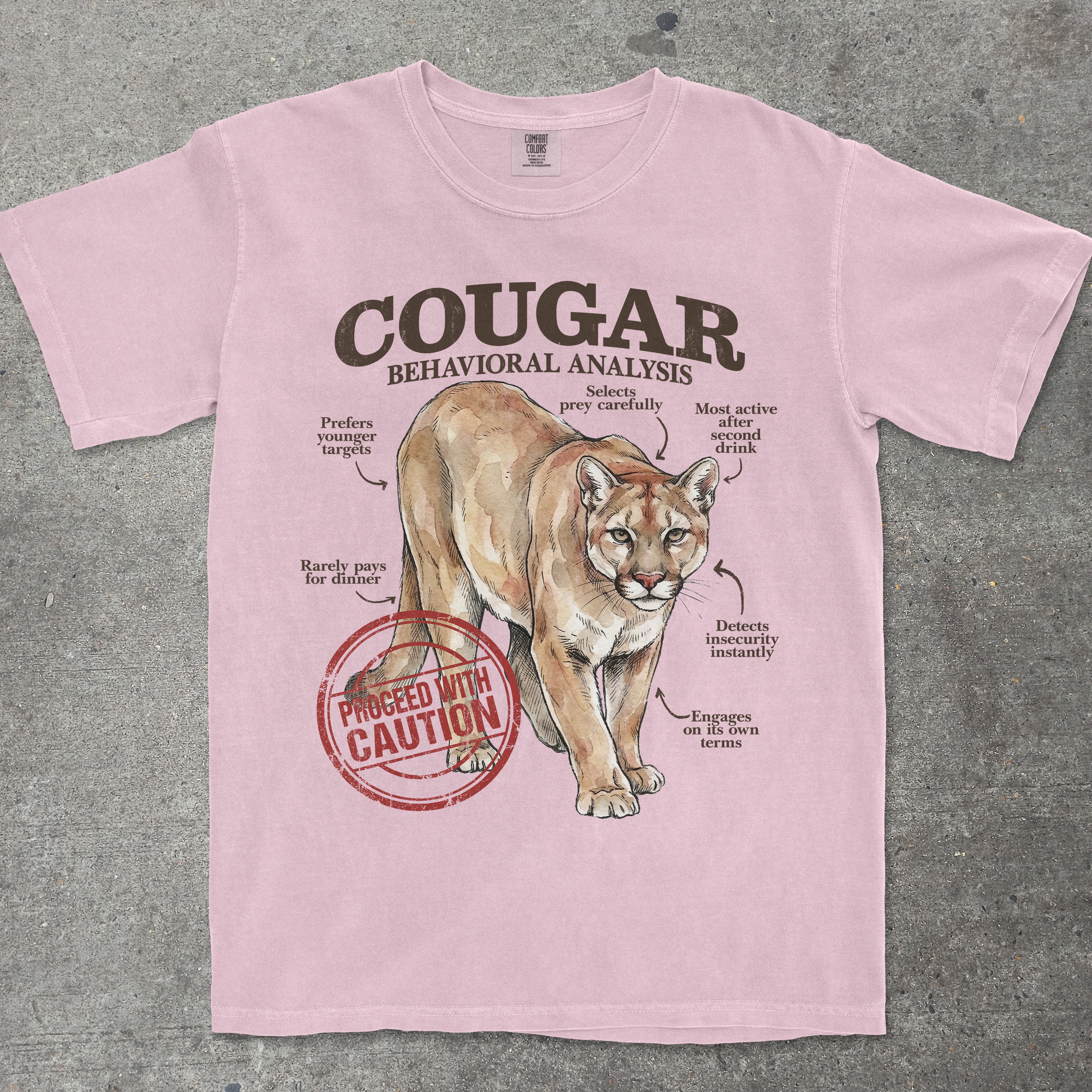 Pink t-shirt with a cougar graphic and text on a gray background