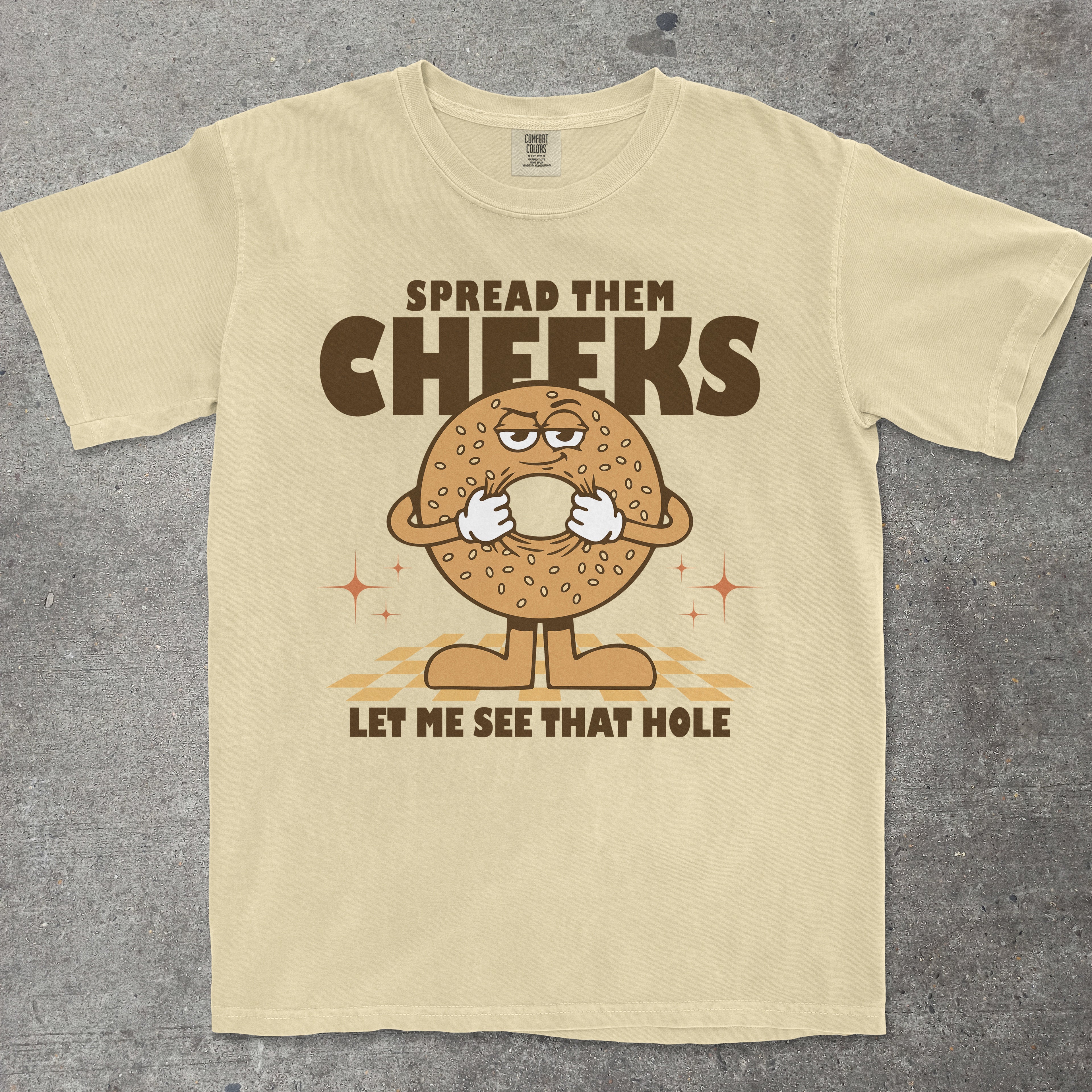Yellow t-shirt with cartoon bagel graphic and humorous text on a gray background