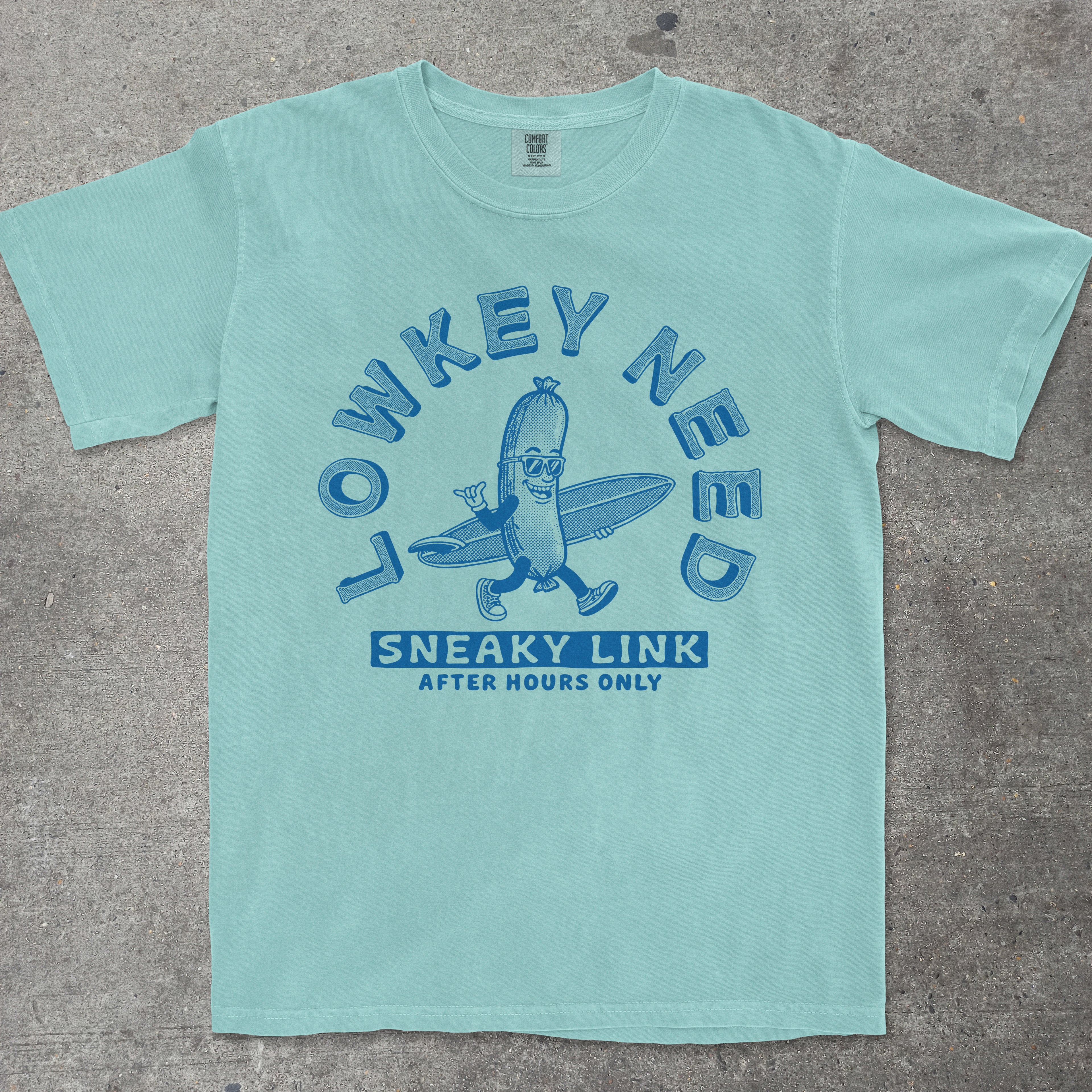 Chalky mint graphic tee featuring retro mascot design with "Lowkey Need Sneaky Link" text by TeeHeeUSCo