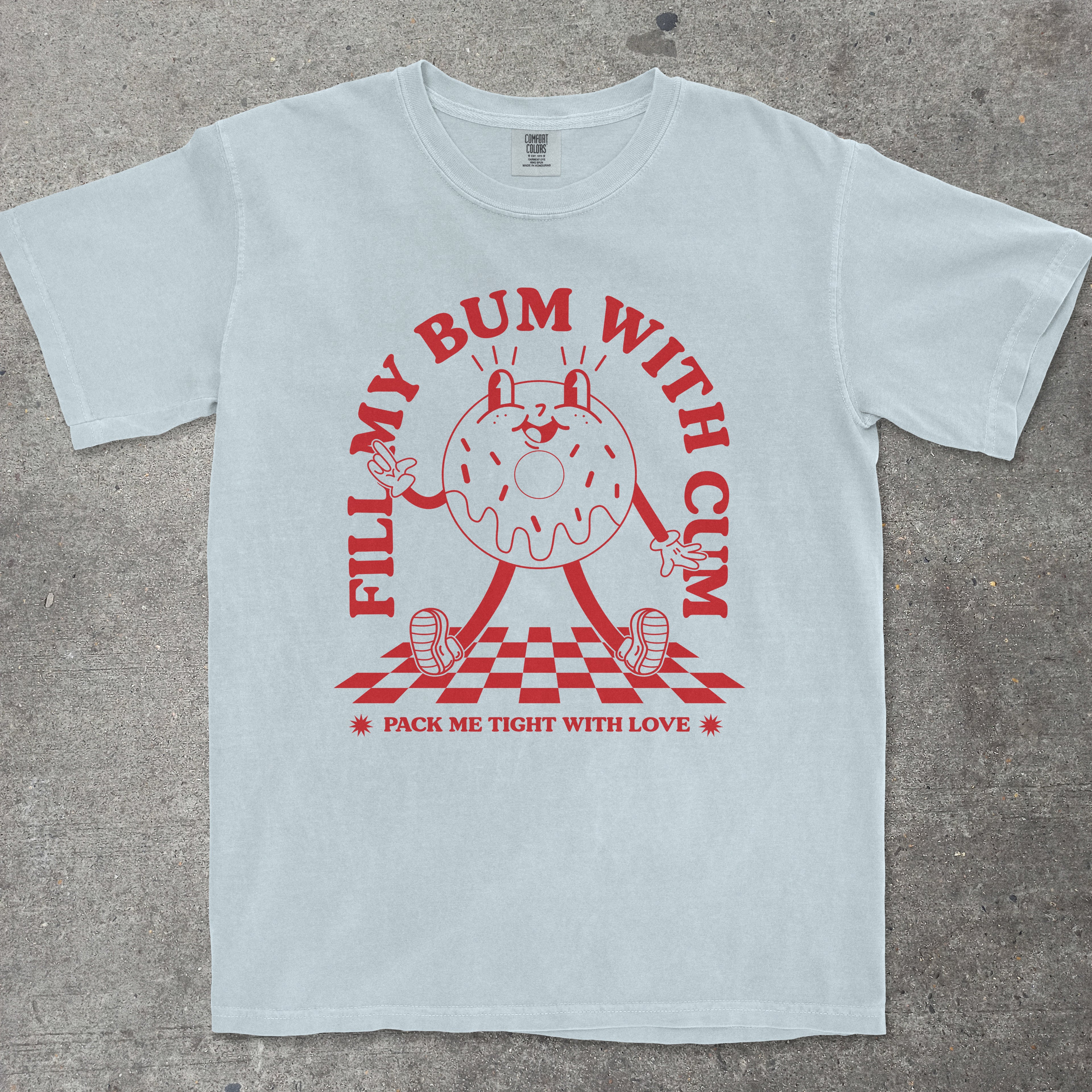 Light blue t-shirt with red graphic design on a concrete surface