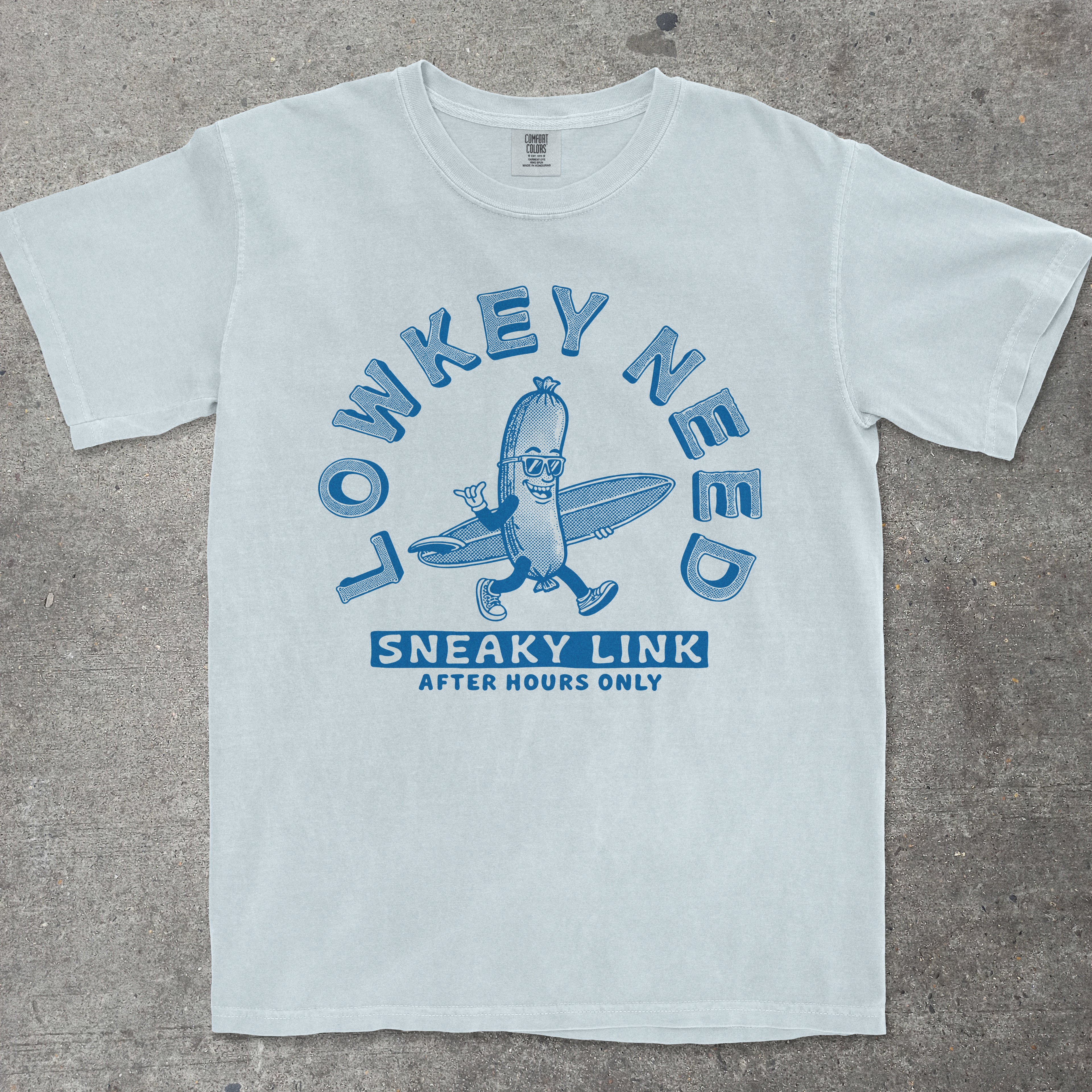 Chambray graphic tee featuring retro mascot design with "Lowkey Need Sneaky Link" text by TeeHeeUSCo