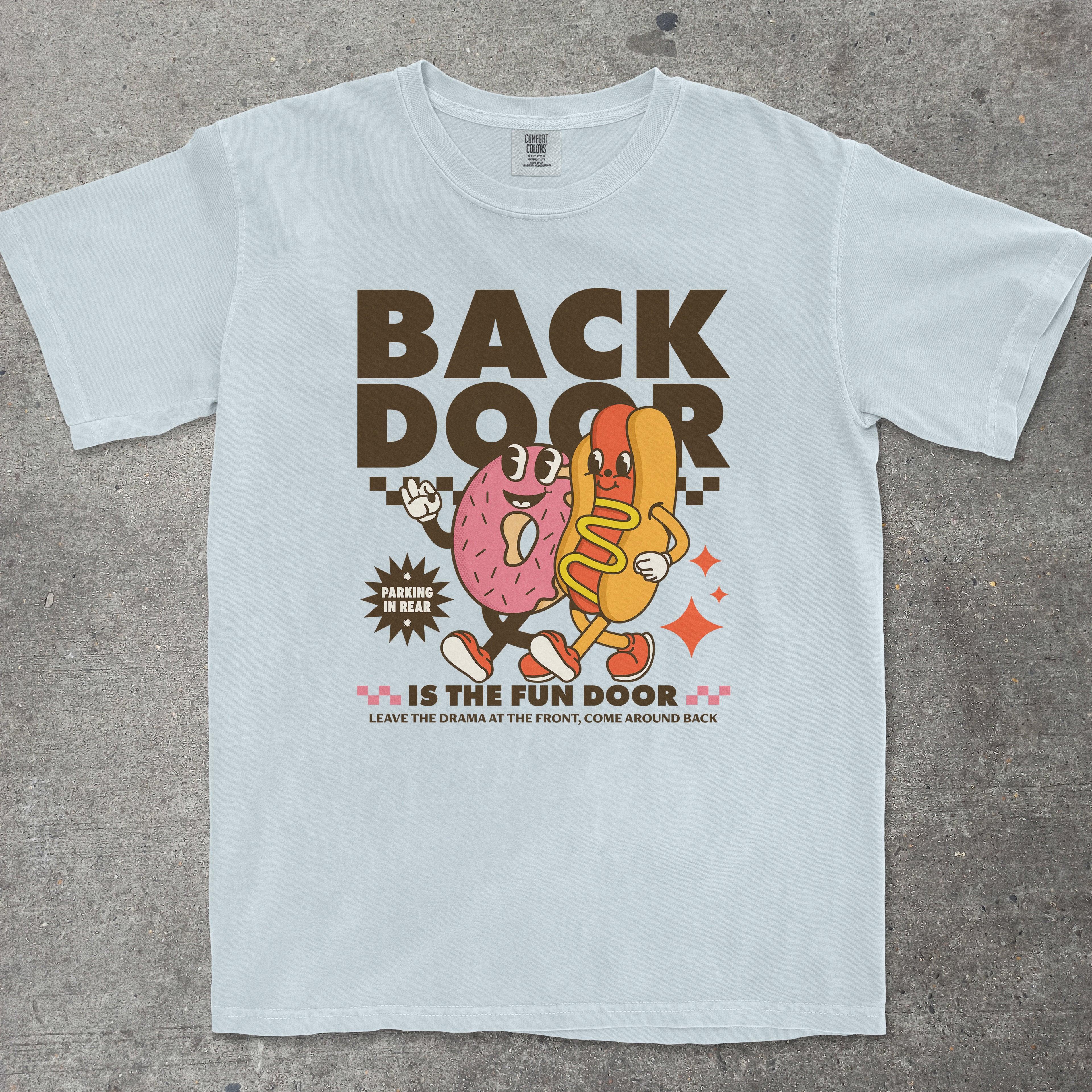 Light blue t-shirt with cartoon characters and text on a gray surface