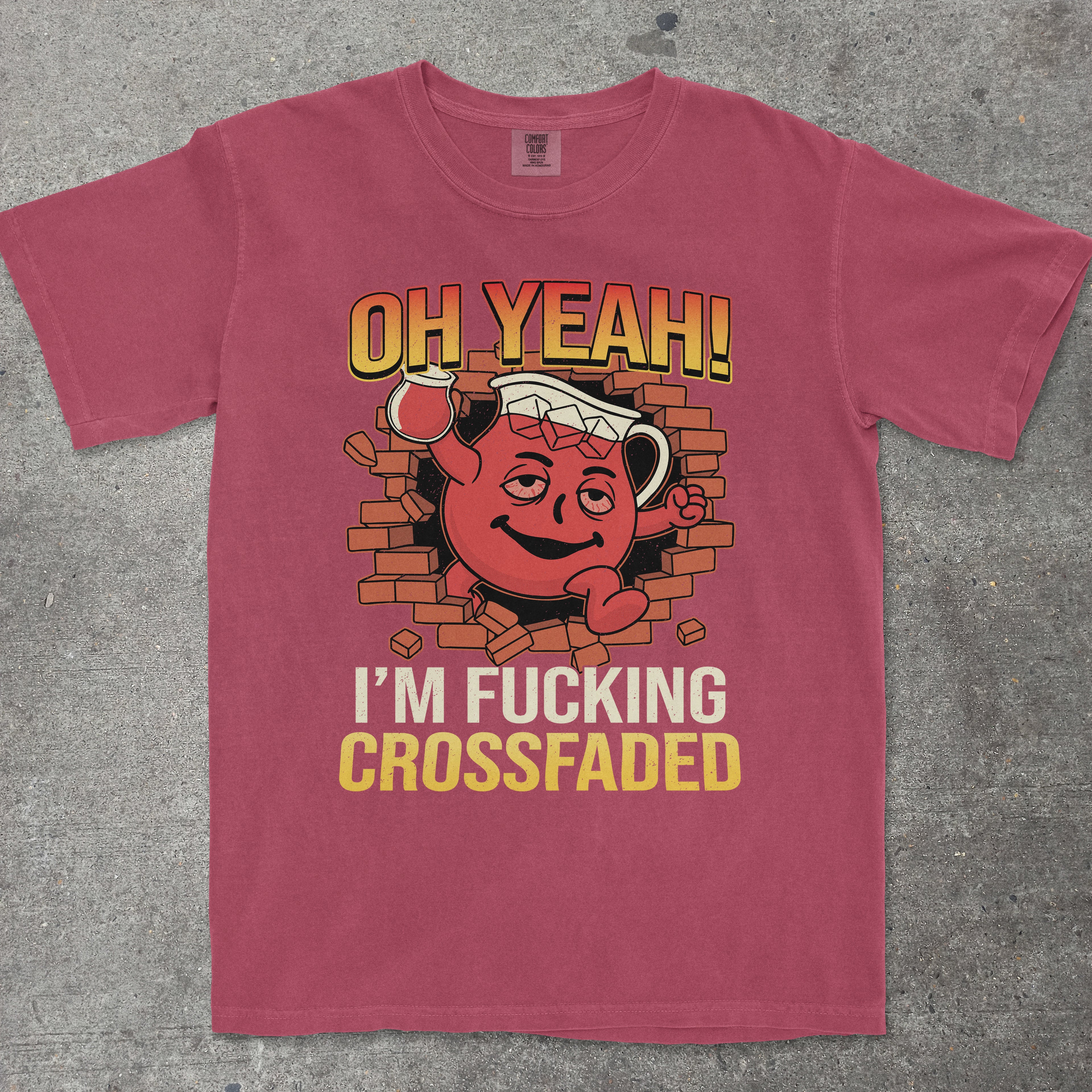 Maroon t-shirt with graphic design and text on a gray surface