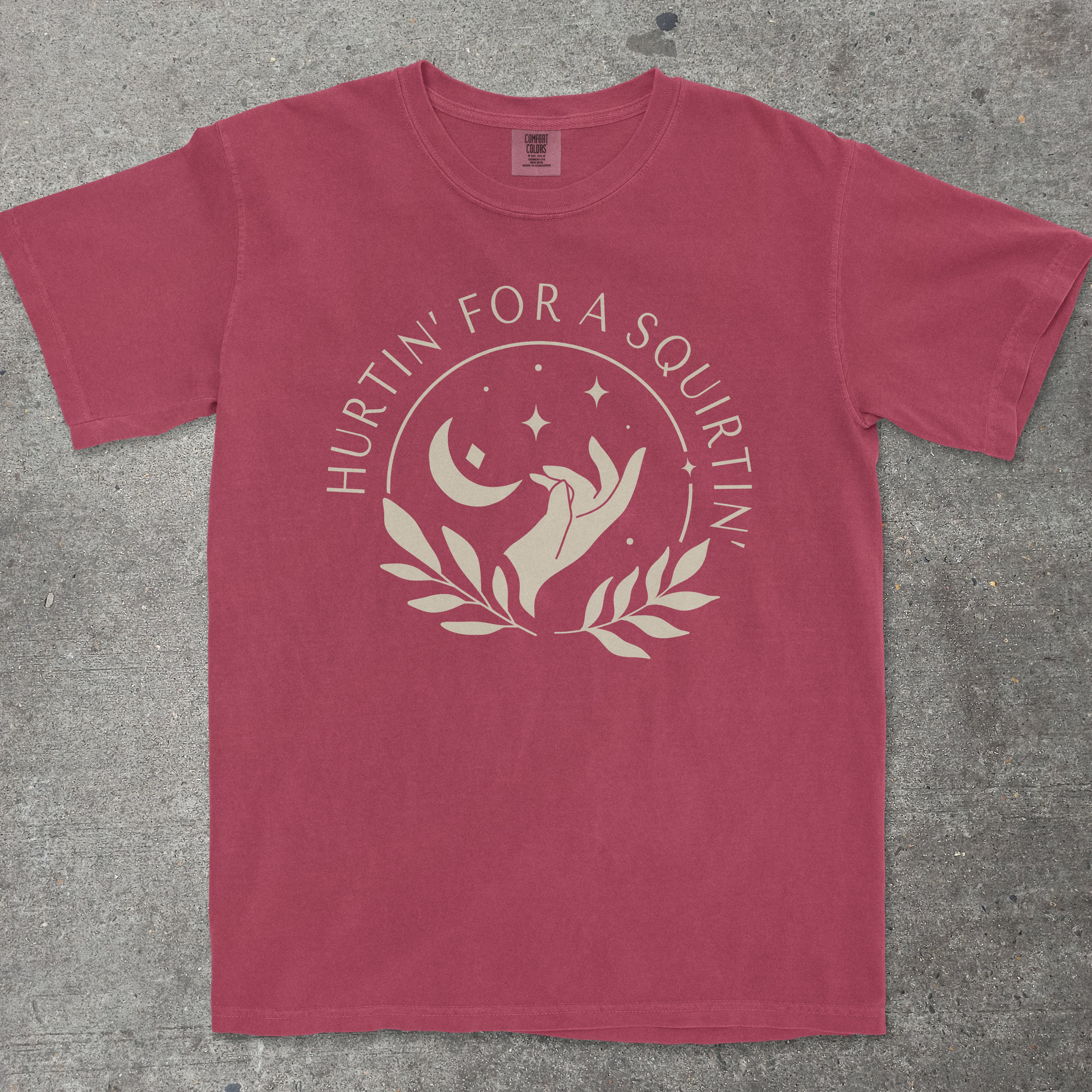 Maroon t-shirt with white graphic and text on a gray surface