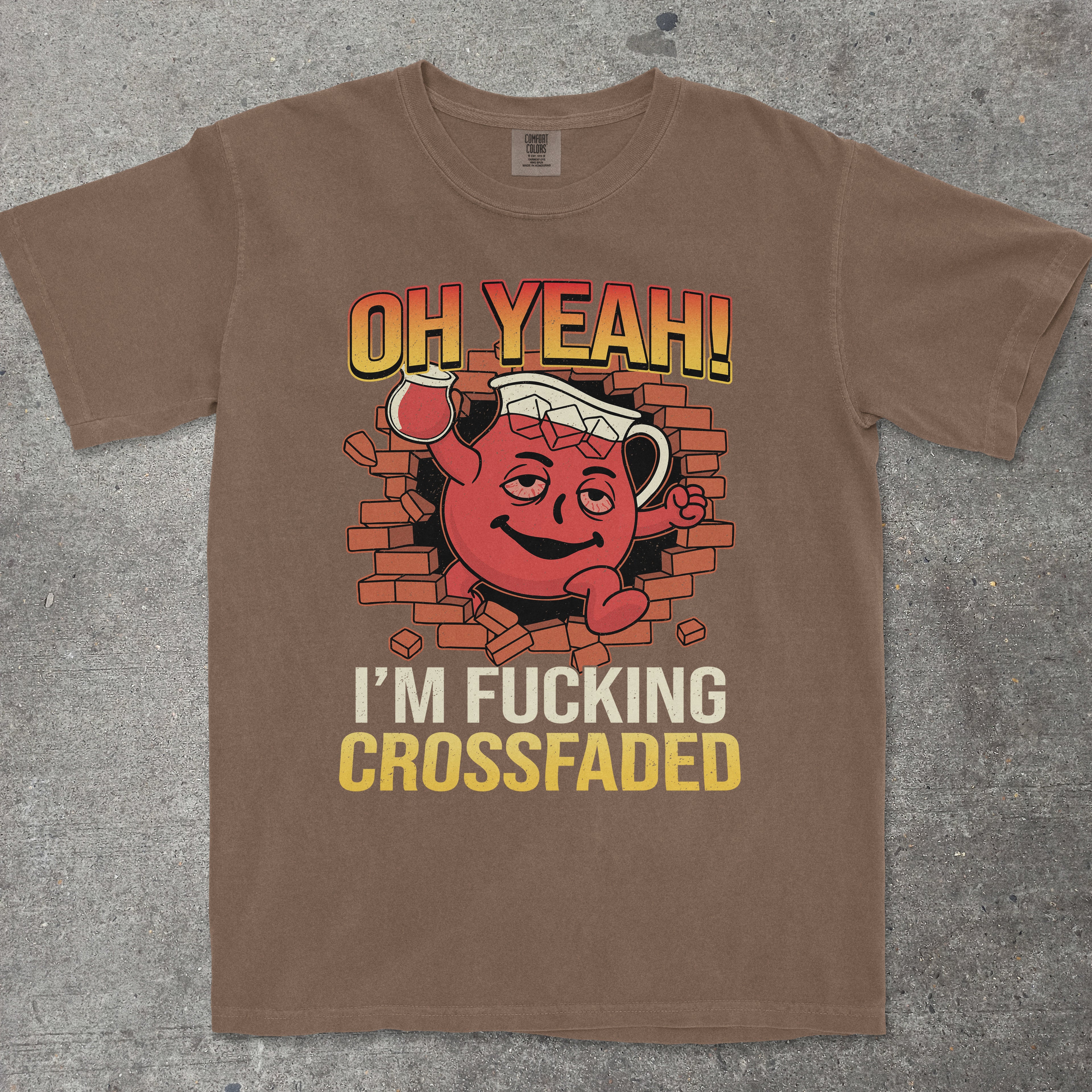 Brown t-shirt with graphic design and text on a gray surface