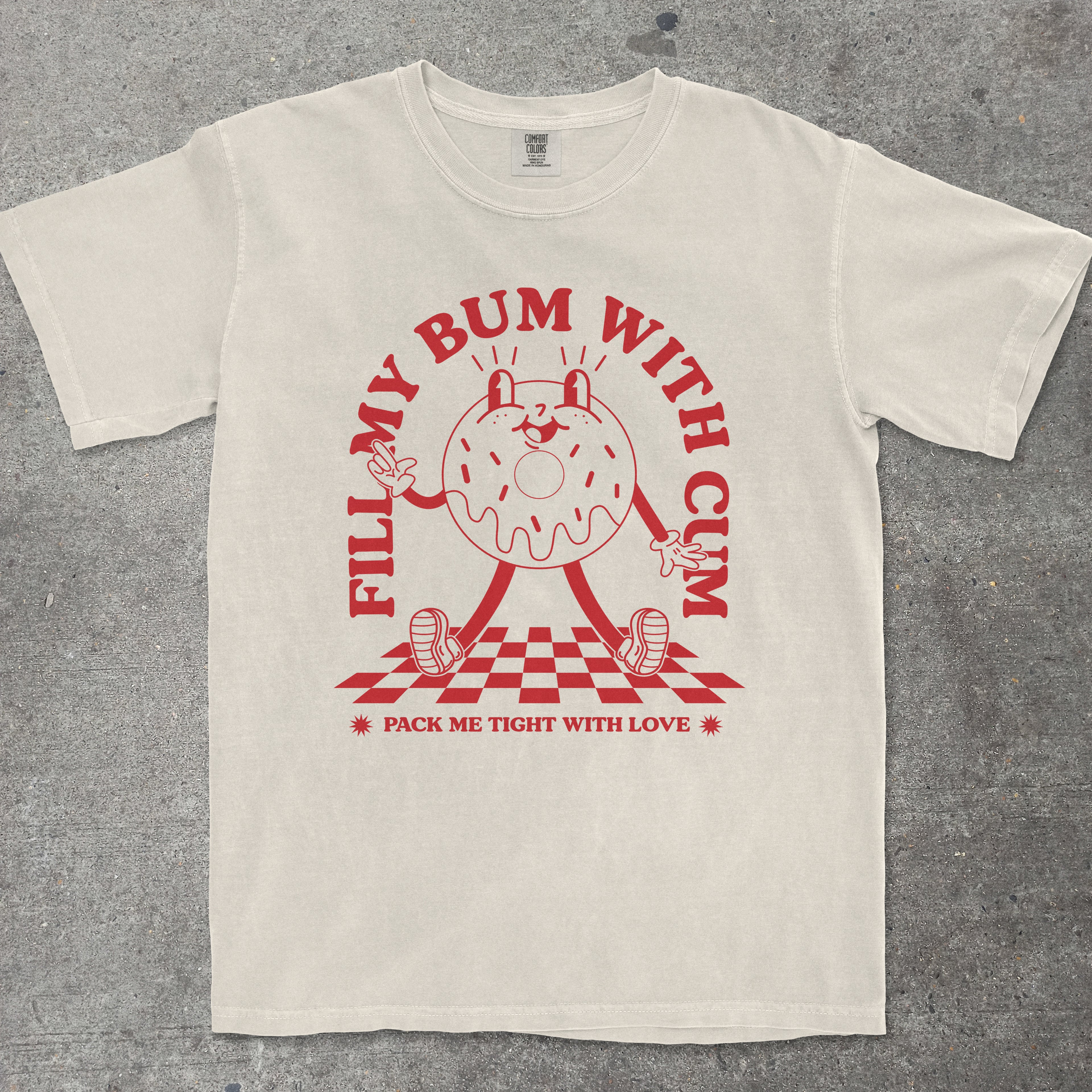Beige t-shirt with red graphic and text on a gray background