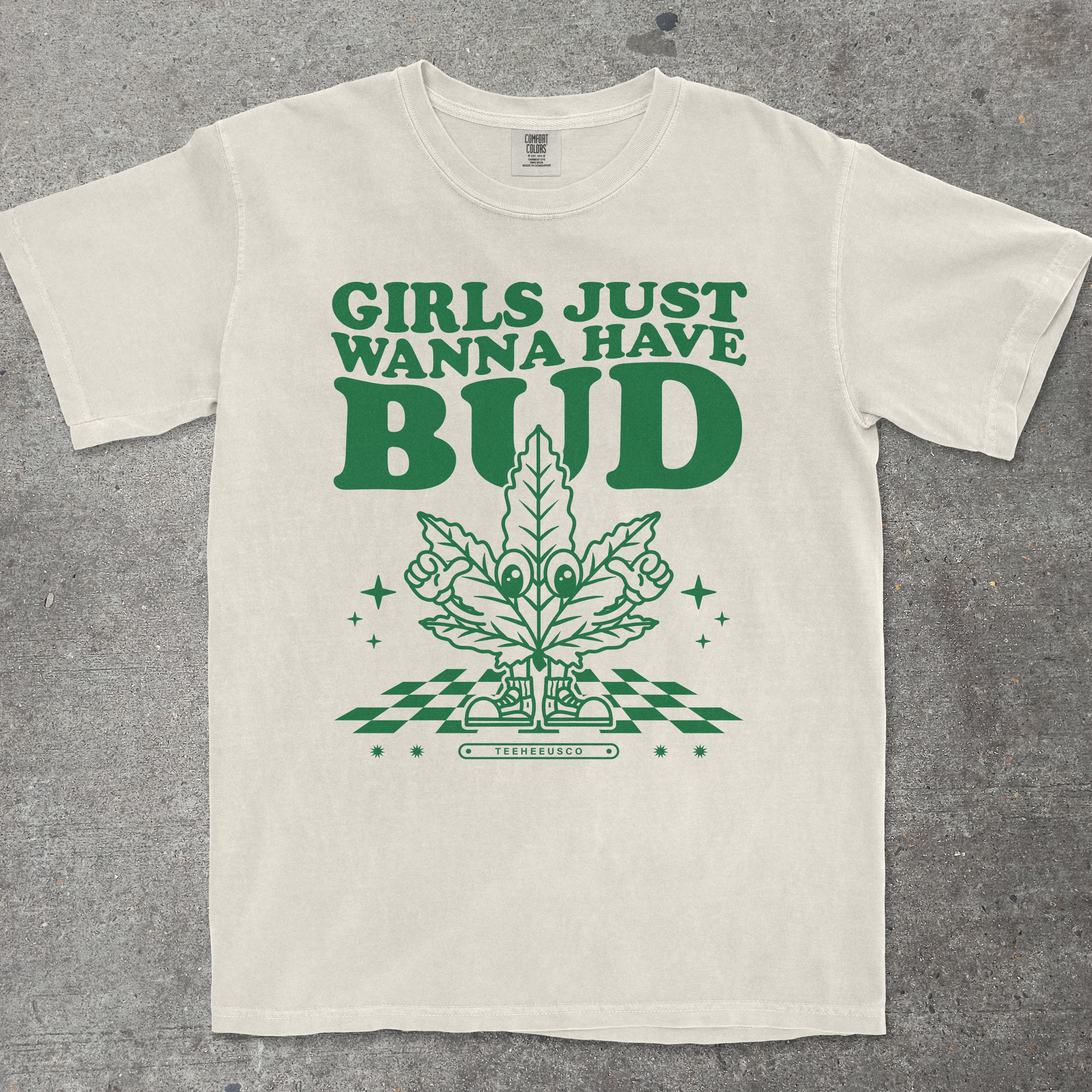 Beige t-shirt with green graphic and text 'Girls Just Wanna Have Bud' on a gray background