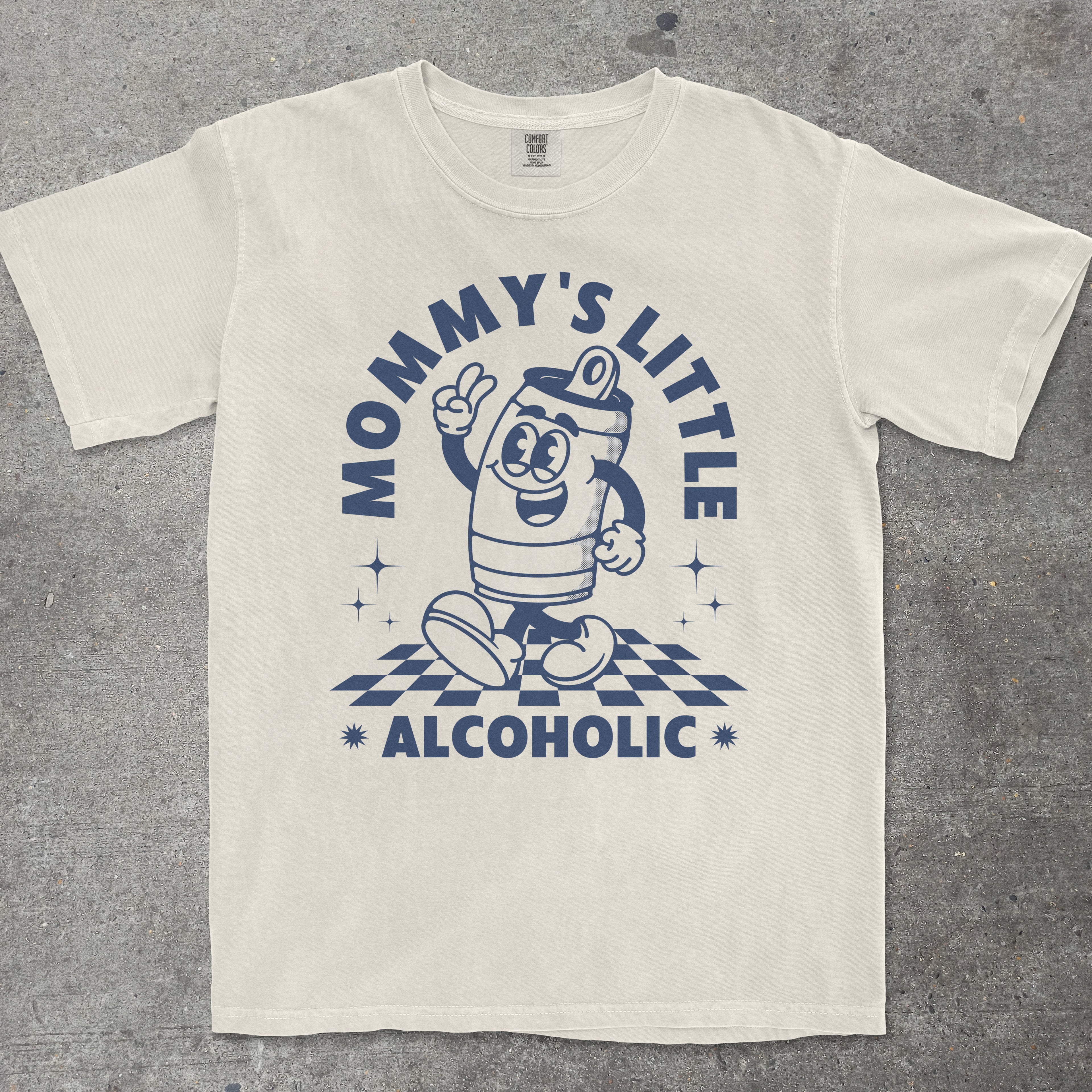 Beige t-shirt with blue graphic and text 'Mommy's Little Alcoholic' on a gray background