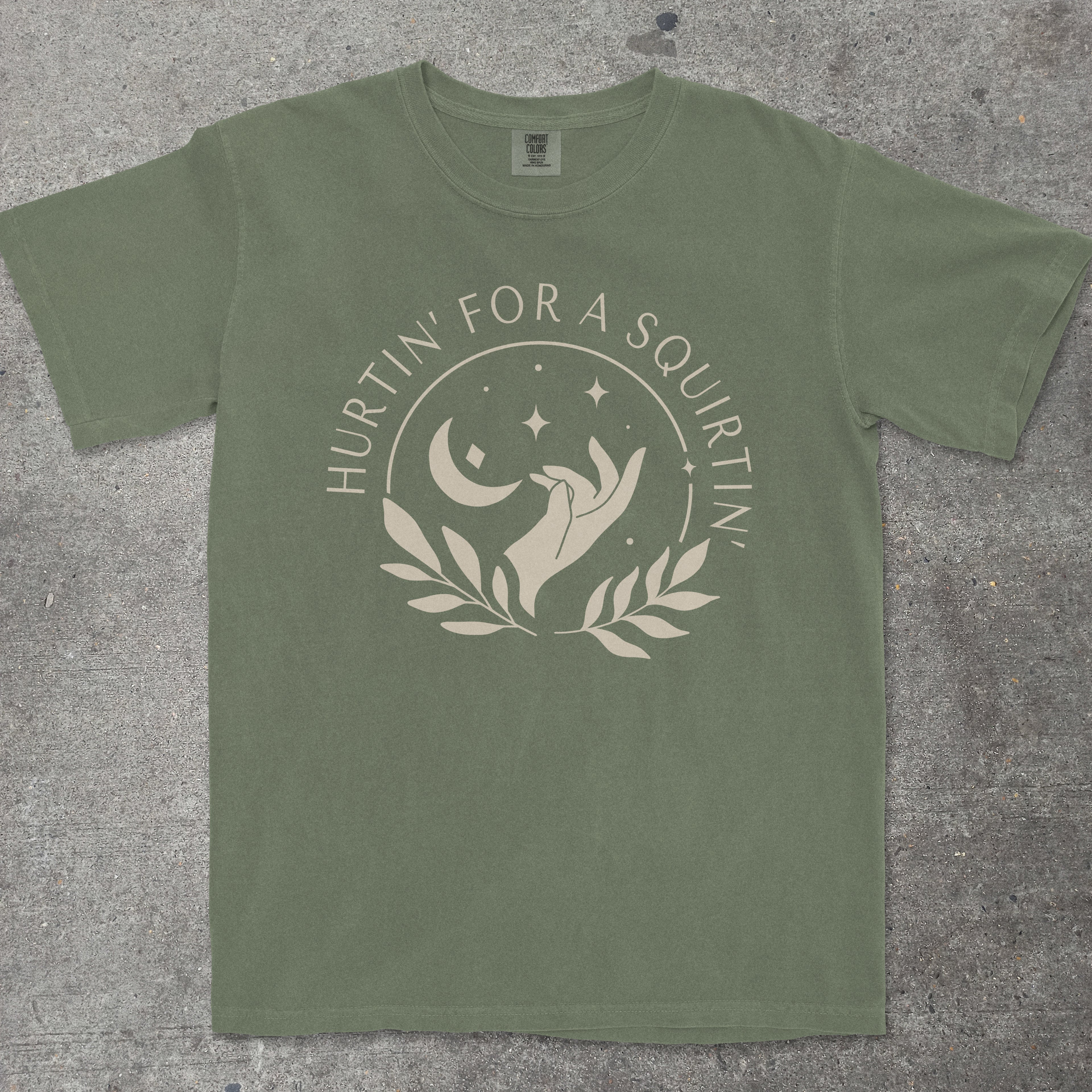 Green t-shirt with graphic design and text on a textured surface