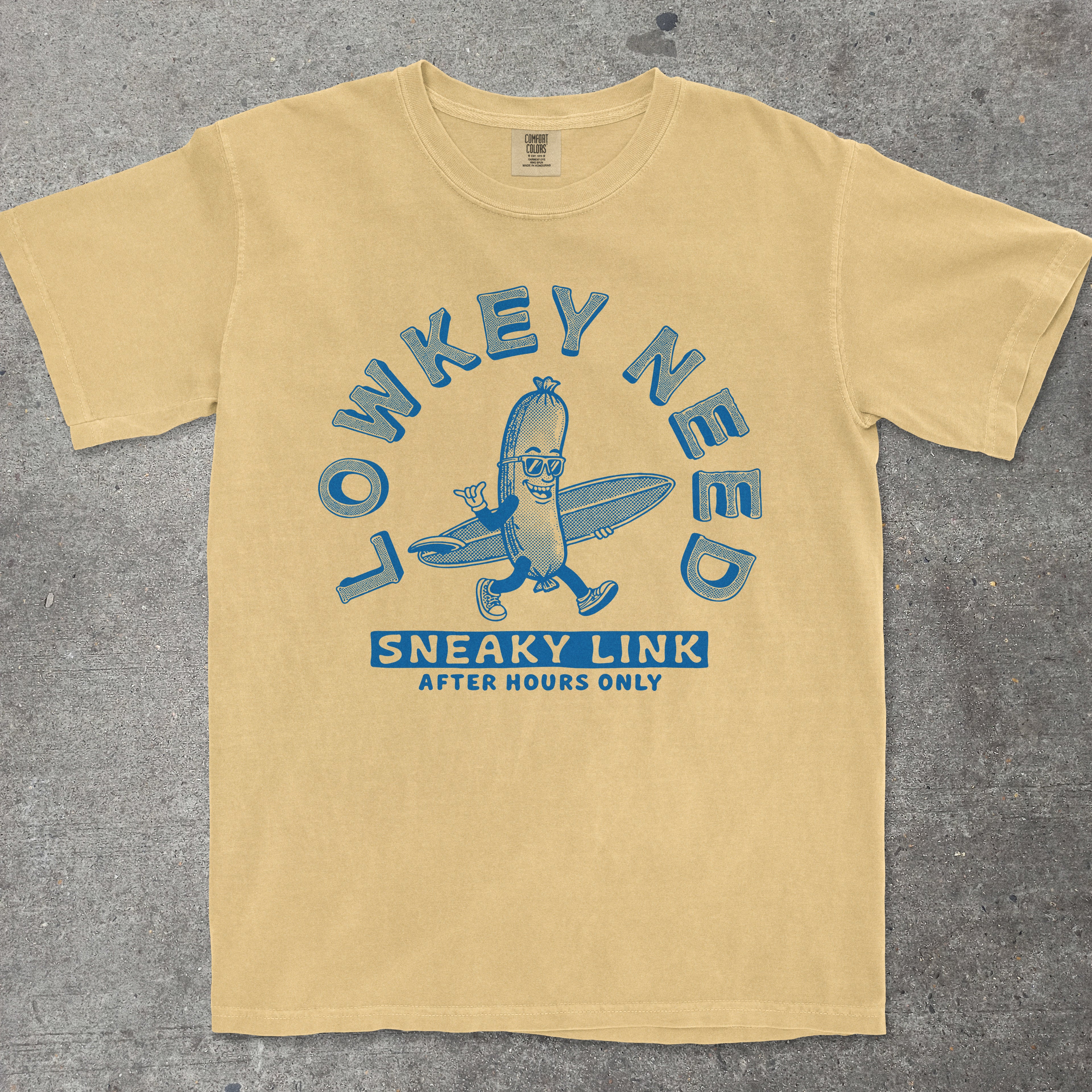 Mustard yellow graphic tee with retro mascot design reading "Lowkey Need a Sneaky Link" by TeeHeeUSCo