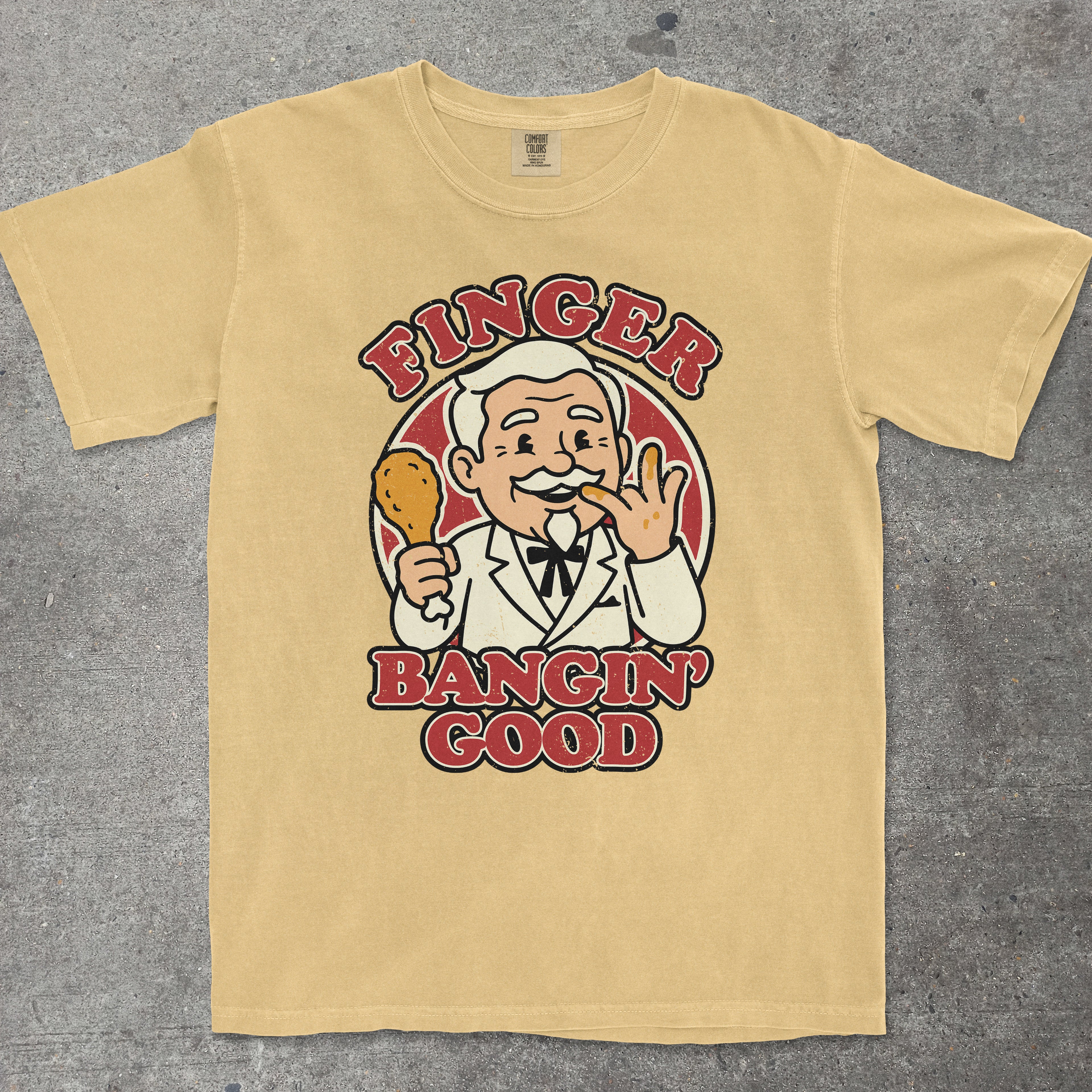 Mustard graphic tee featuring a smug vintage mascot character with "Finger Bangin Good" text - TeeHeeUSCo