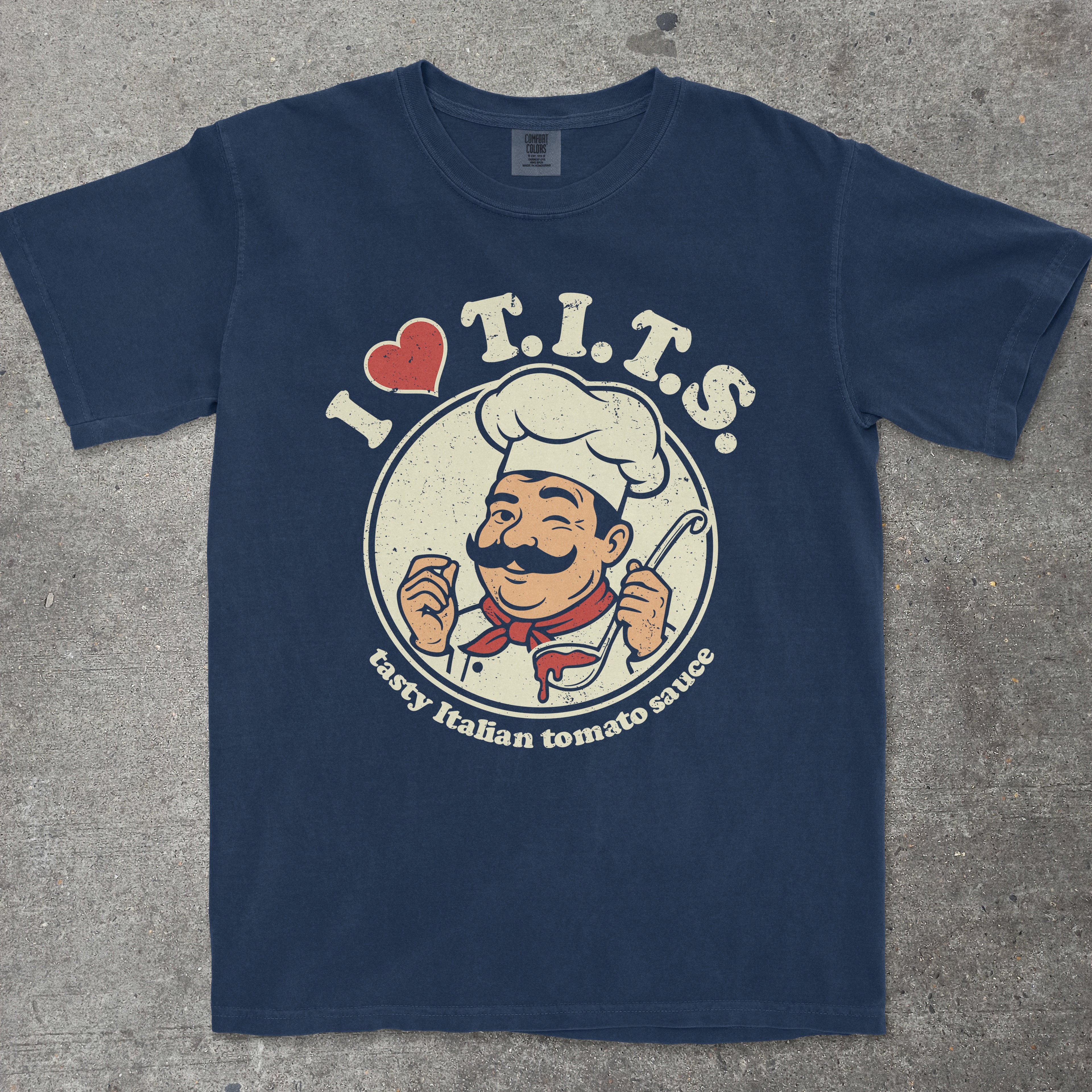 Navy graphic tee featuring retro chef mascot with "I LOVE T.I.T.S." text design by TeeHeeUSCo