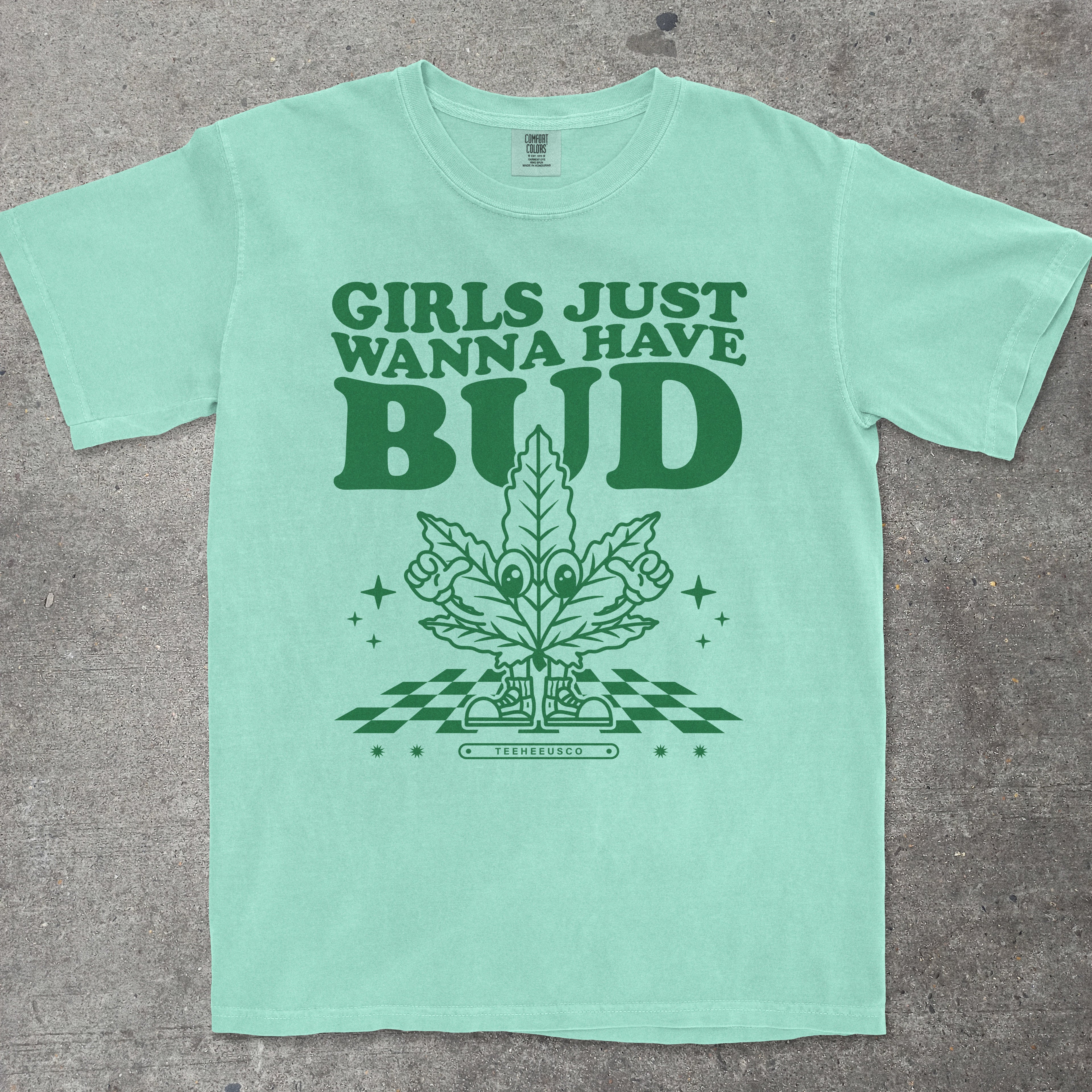 Mint green t-shirt with green text and graphic on a gray surface