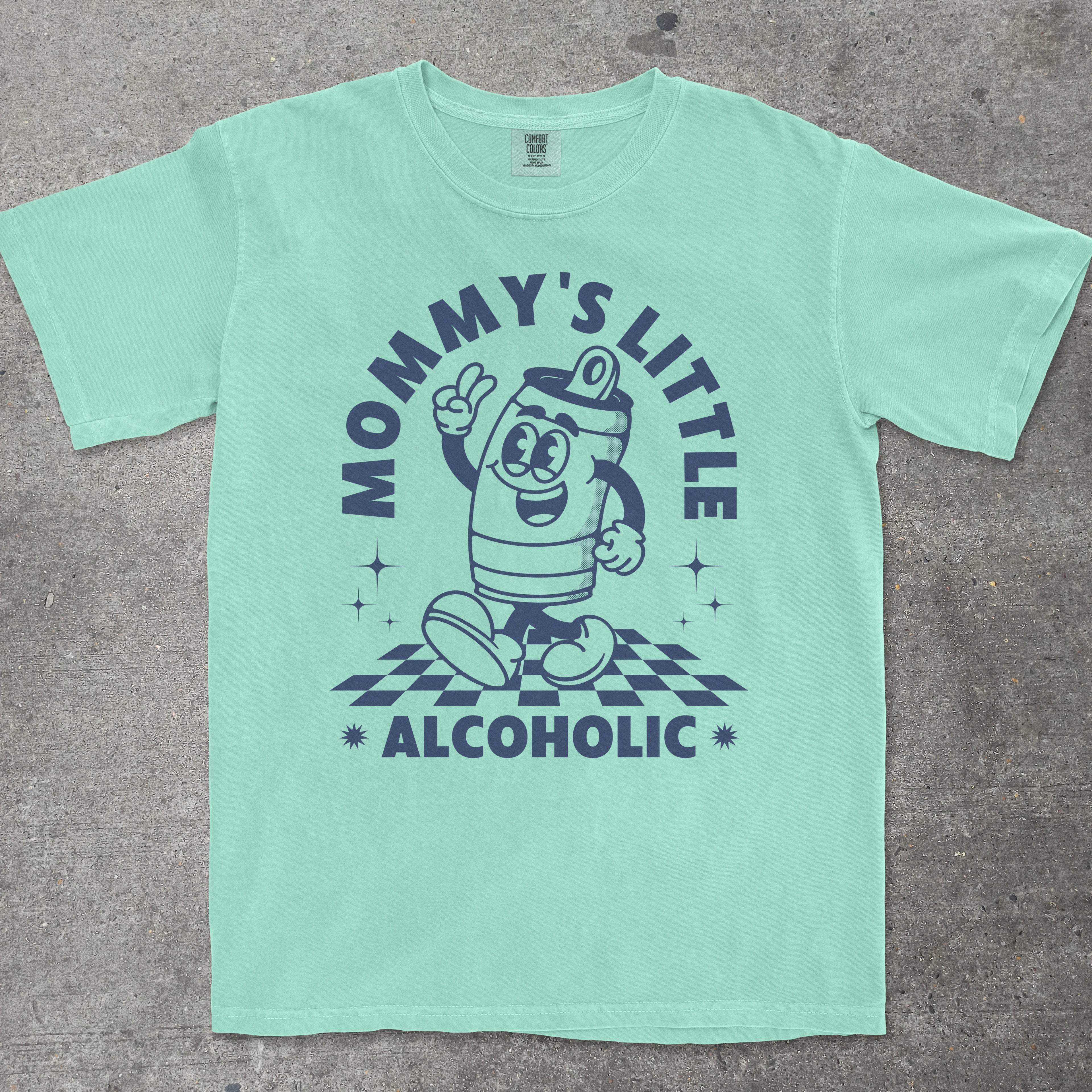 Mint green t-shirt with cartoon character and text on a gray surface