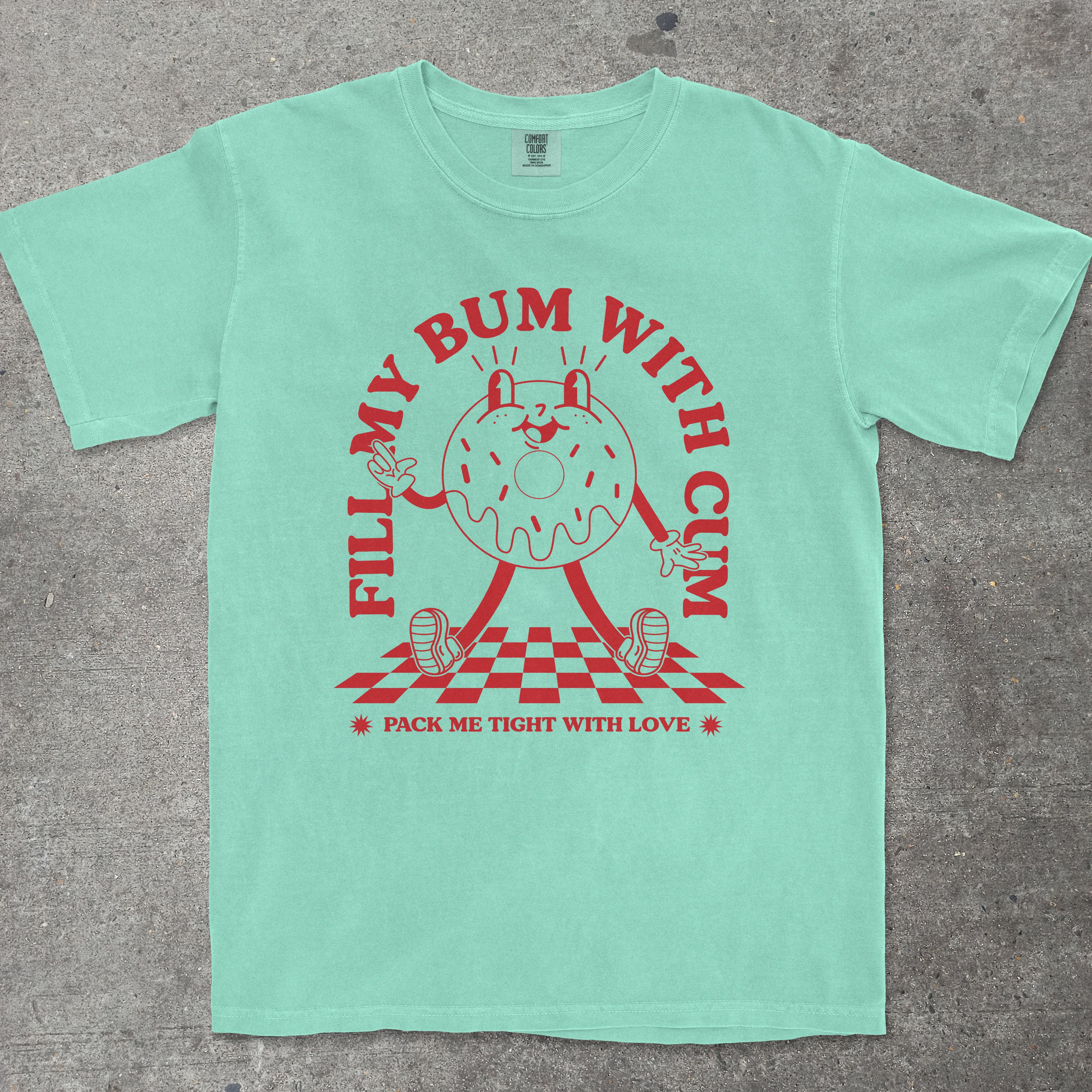 Mint green t-shirt with red graphic design on a gray surface