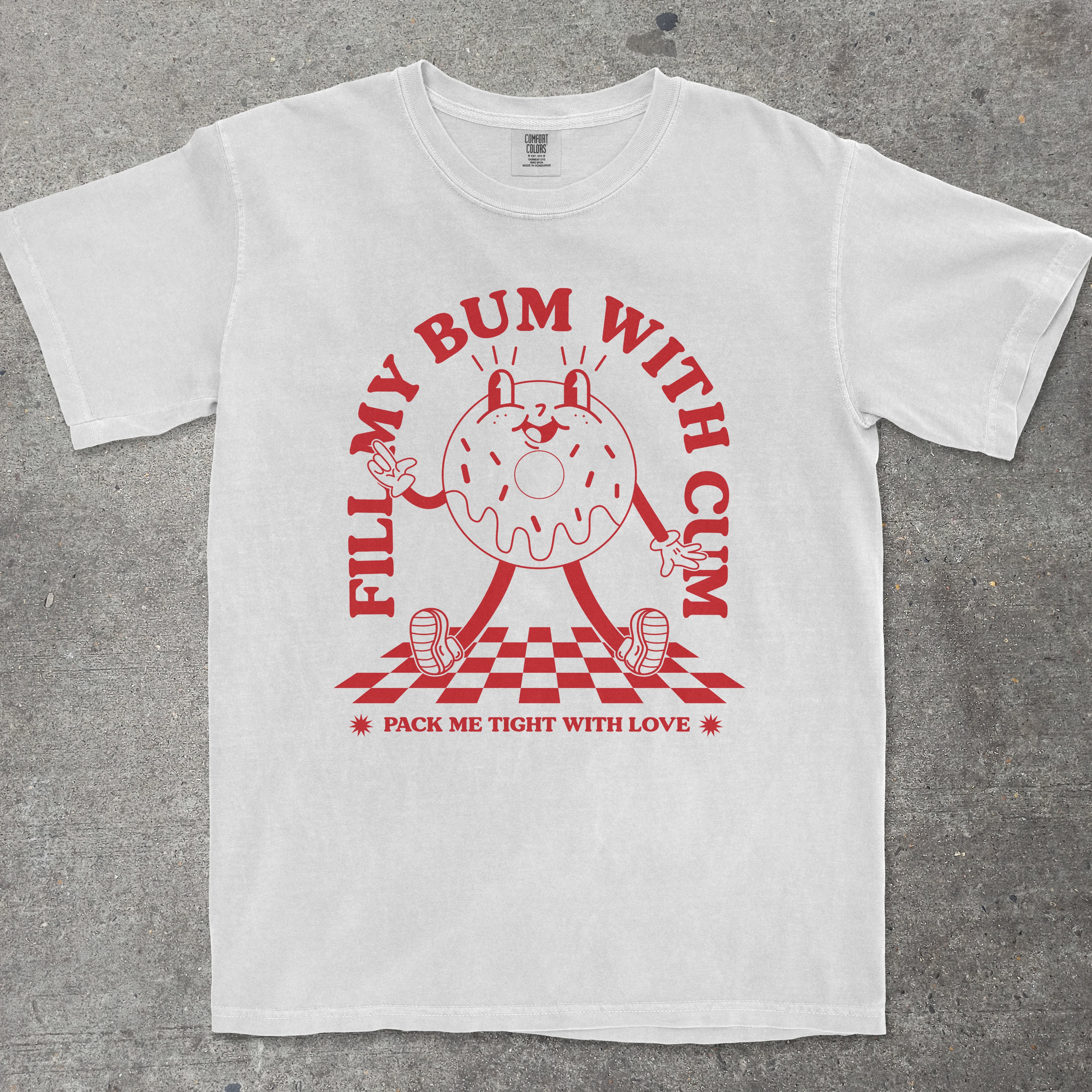 White t-shirt with red graphic and text on a gray surface